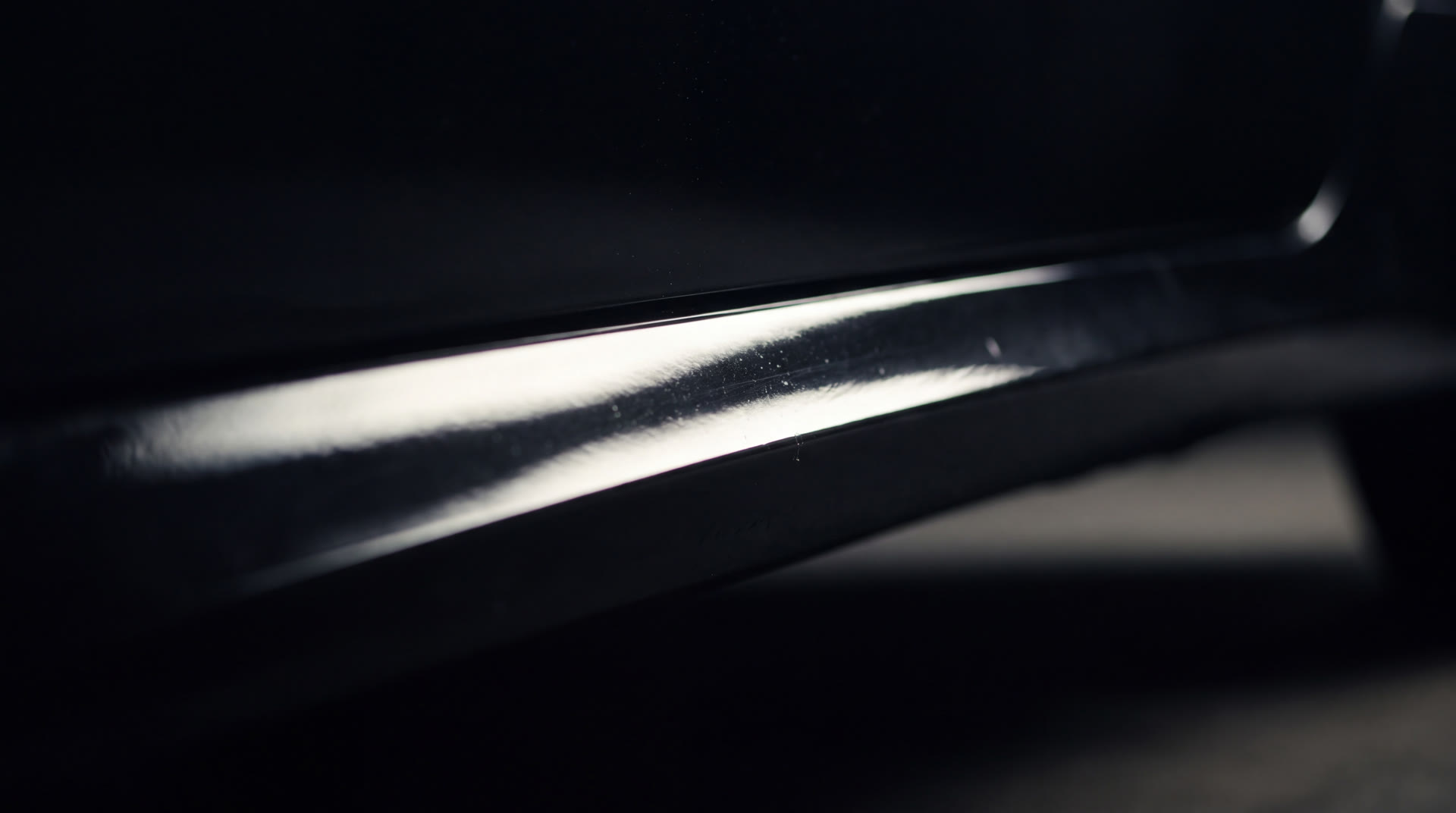 Macro de pintura negra con brillo de espejo bajo luz dirigida